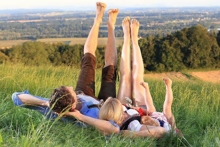 Familienausflug Bayerischer Wald (© Rio Patuca/ Fotolia) Foto einer Familie im Gras liegend im Bayerischen Wald