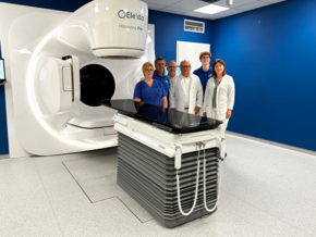 (©Heike Korber) Priv.-Doz. Dr. Christof Schäfer (4. von links), Leiter der Strahlentherapie am Klinikum Straubing, steht mit einem Teil seines Teams vor dem neuen Linearbeschleuniger.
