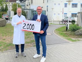 Foto von PD Dr. Jochen Grassinger, Direktor des Onkologischen Zentrums  (l.), der die Spende von Thomas Lehmann, Geschäftsführer der Firma BMS Maschinenfabrik GmbH, entgegennimmt