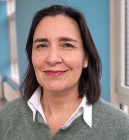 Dr. Cecilia Jara (© Johannes Lehner) Mit grauer Wollweste und heller Bluse drunter, Lippenstift, dunkelbraune schulterlange Haare